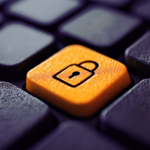 Imagem de um teclado de computador com uma tecla laranja de segurança ativada com um cadeado. Tema relacionado a proteção de informações digitais, privacidade e crimes cibernéticos.
